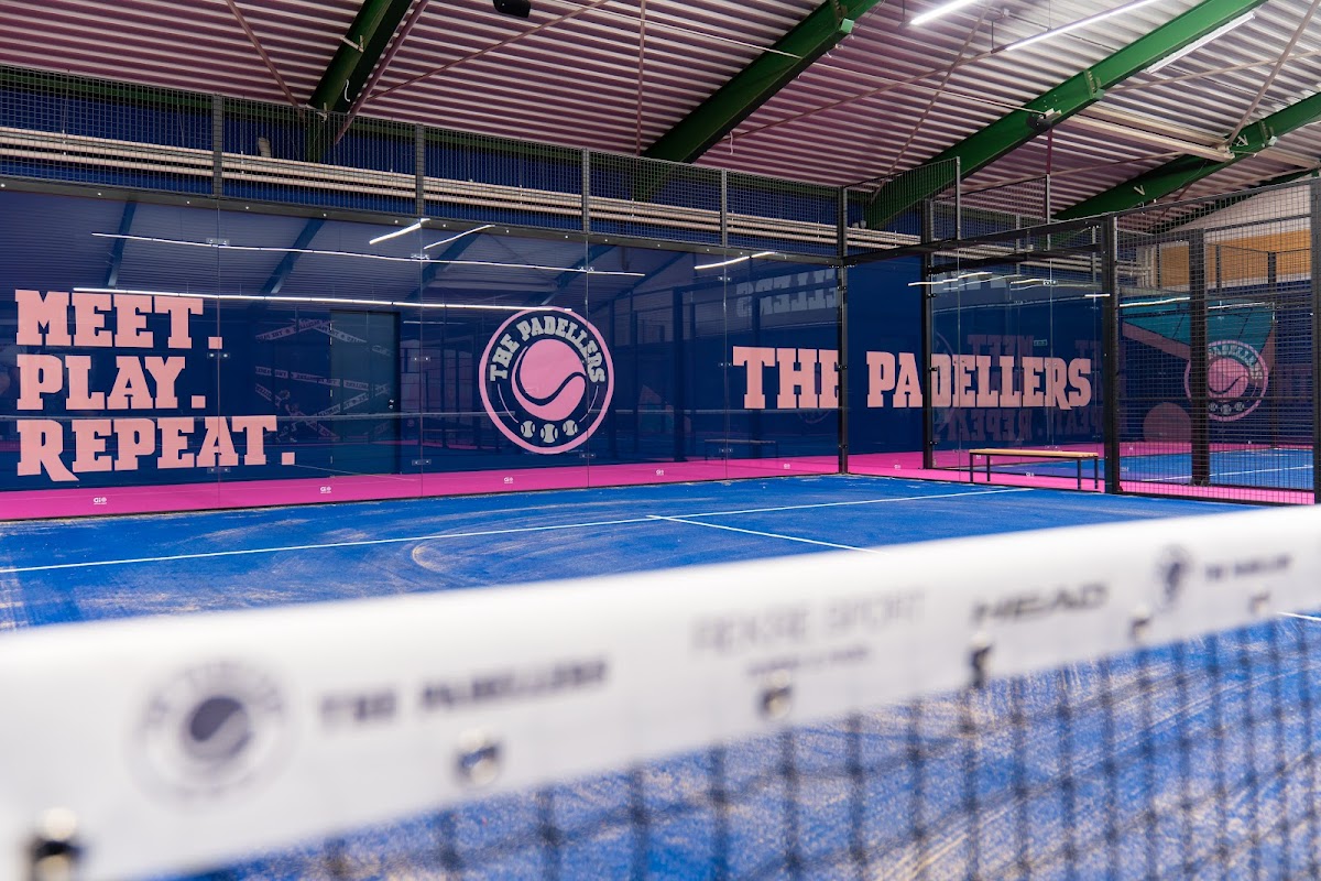 Moderne indoor padelclub The Padellers met blauwe banen en roze branding