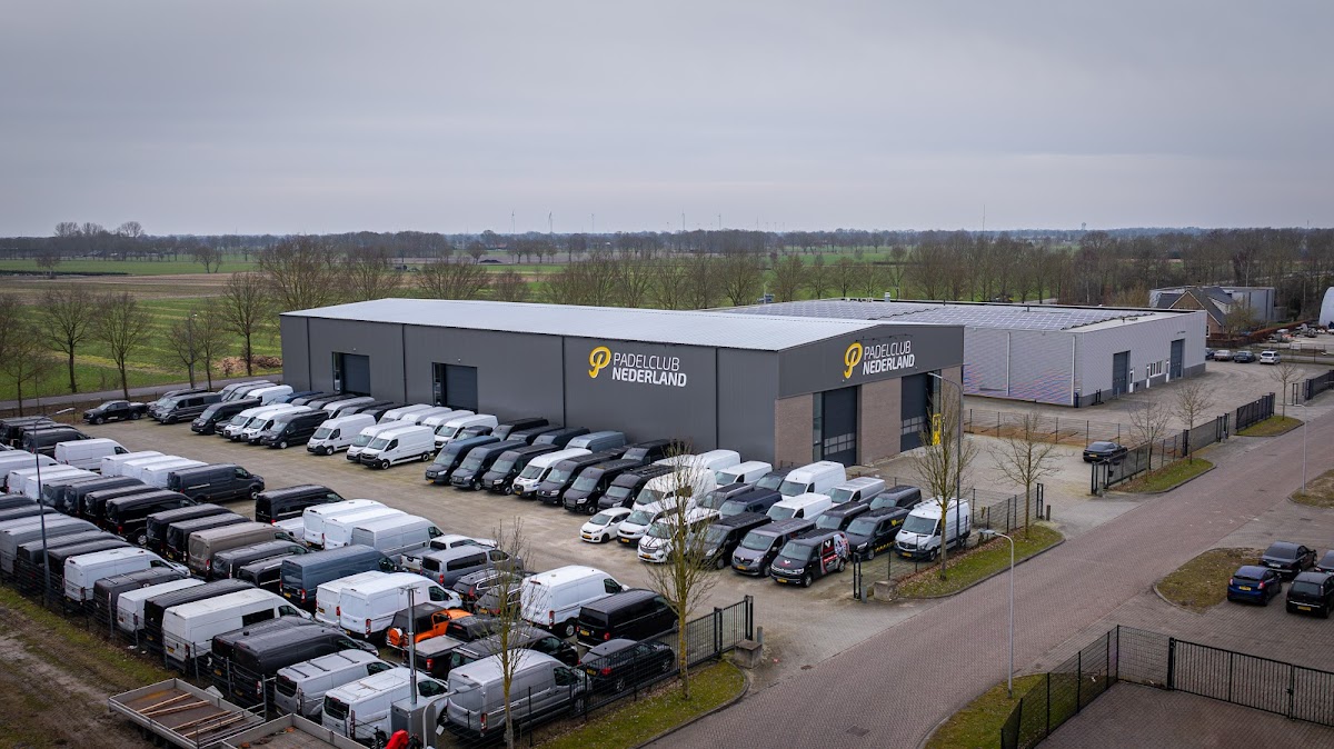 Padelclub Nederland faciliteit met parkeerplaats en trailers, landelijk uitzicht
