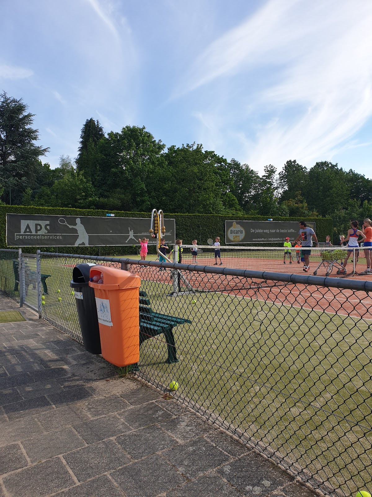 Outdoor padelbaancomplex met groene kunstgrasondergrond en gaasafscheidingen tussen de banen