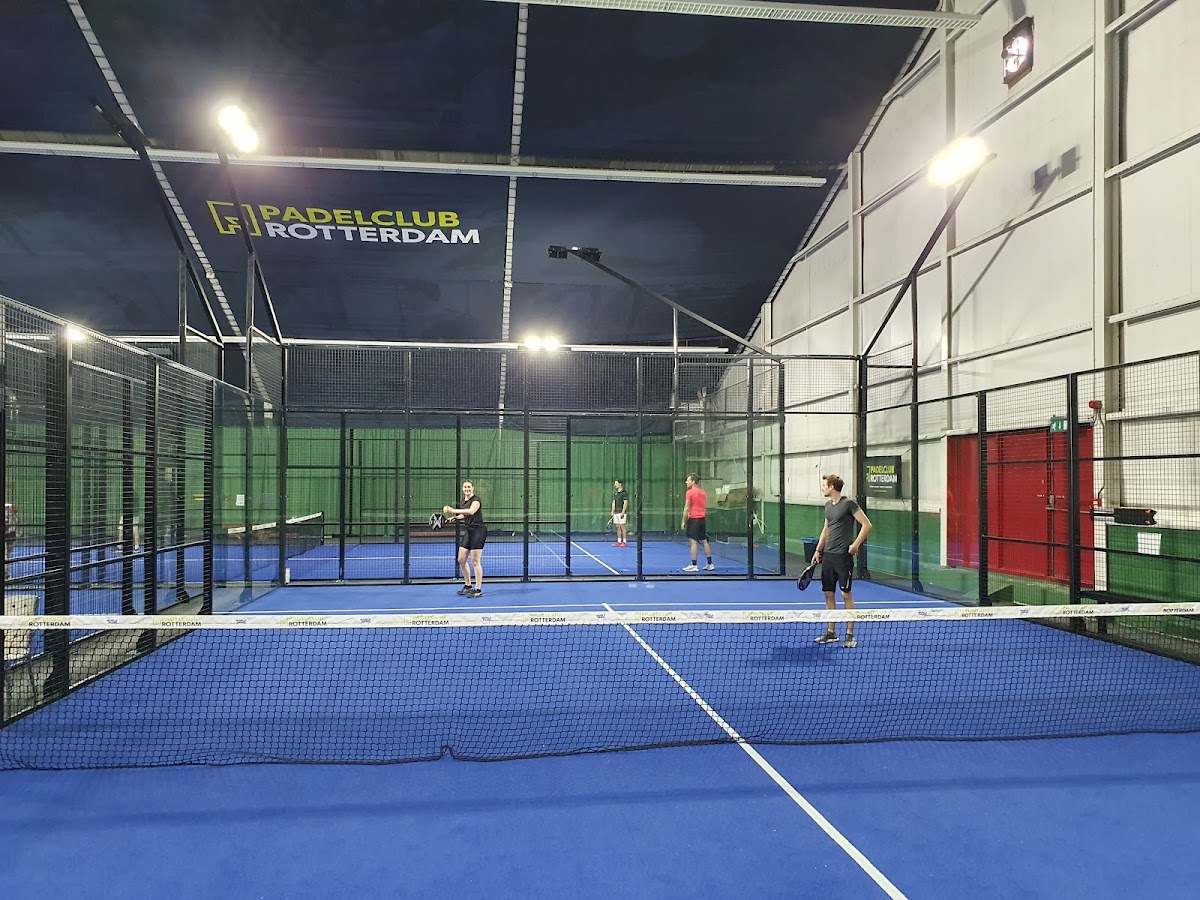 Padelclub Rotterdam met blauwe QuickPadel courts en spelers in actie onder LED-verlichting