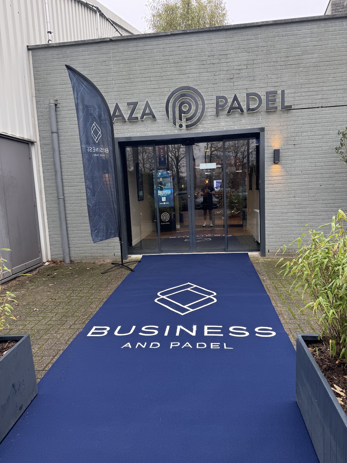 Ingang van Plaza Padel club met blauwe loopmat en Business and Padel branding