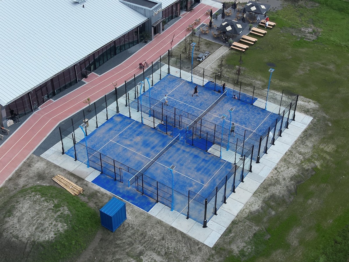 Luchtfoto van outdoor padelclubs met vier blauwe banen en zwarte netten