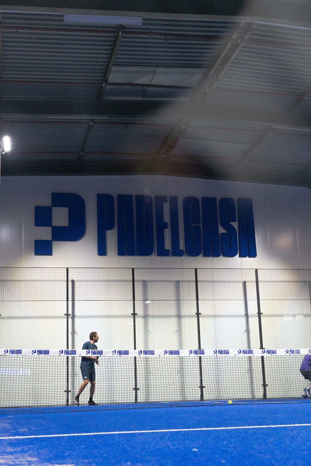 Padelbaan met blauwe ondergrond in Padilosa faciliteit met speler