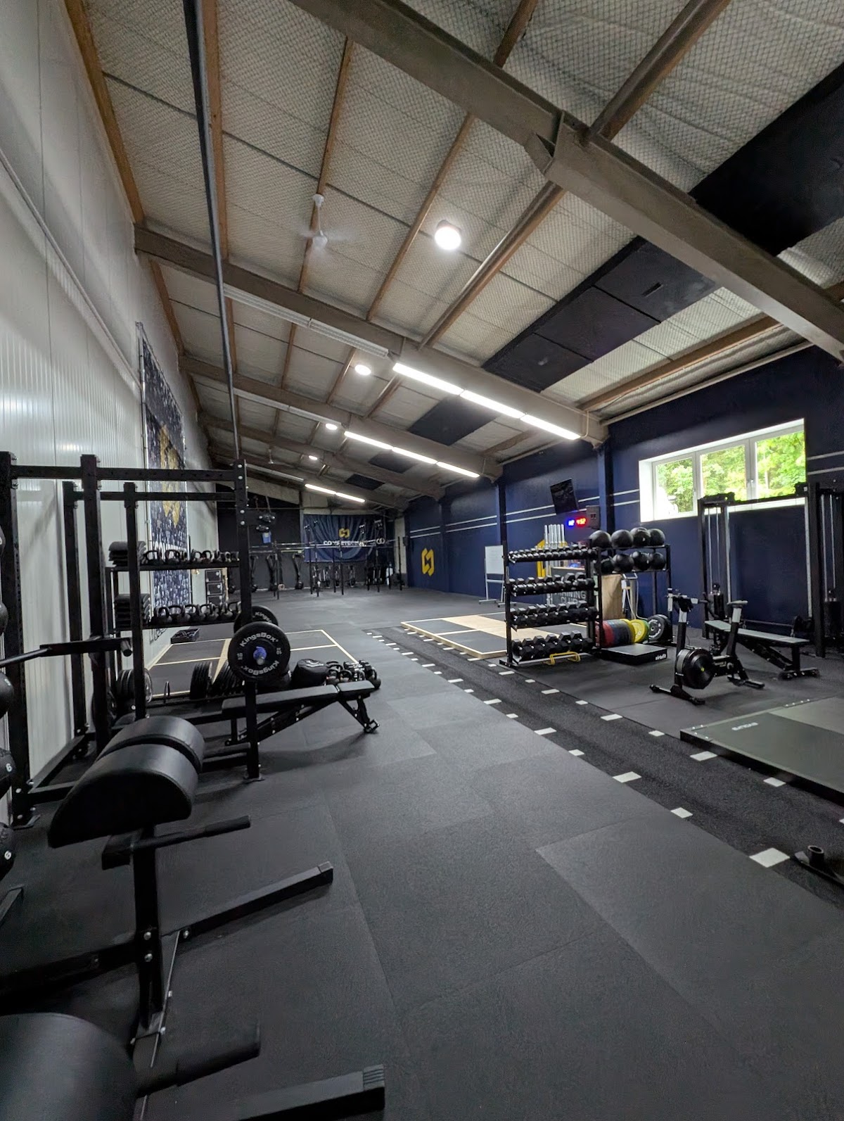 Modern overdekte padelbaan met zwarte vloer, trainingsequipment en LED-verlichting