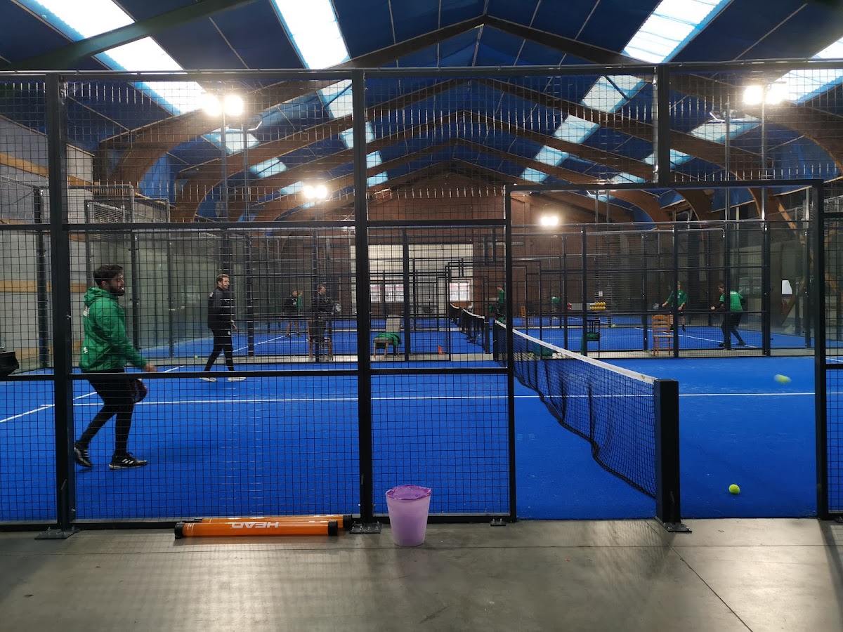 Indoor padelclub met blauwe kunstofgrass courts, zwarte netten en LED-verlichting