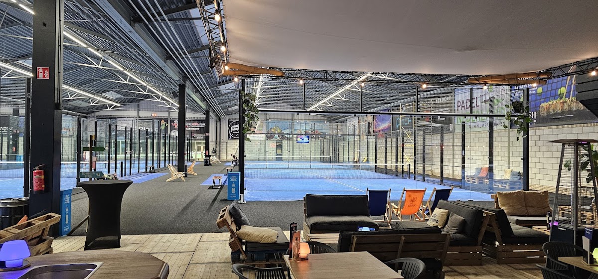 Moderne indoorbaan met blauwe Quick Padel-velden, zitgedeelte en professionele verlichting