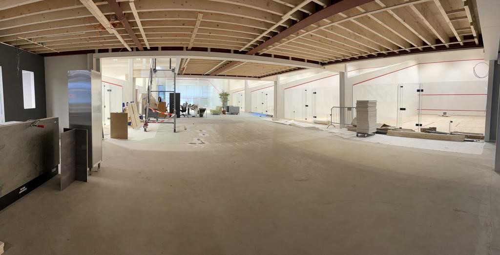 Interieur van een padel club met meerdere courts, betonnen vloer en moderne afwerking