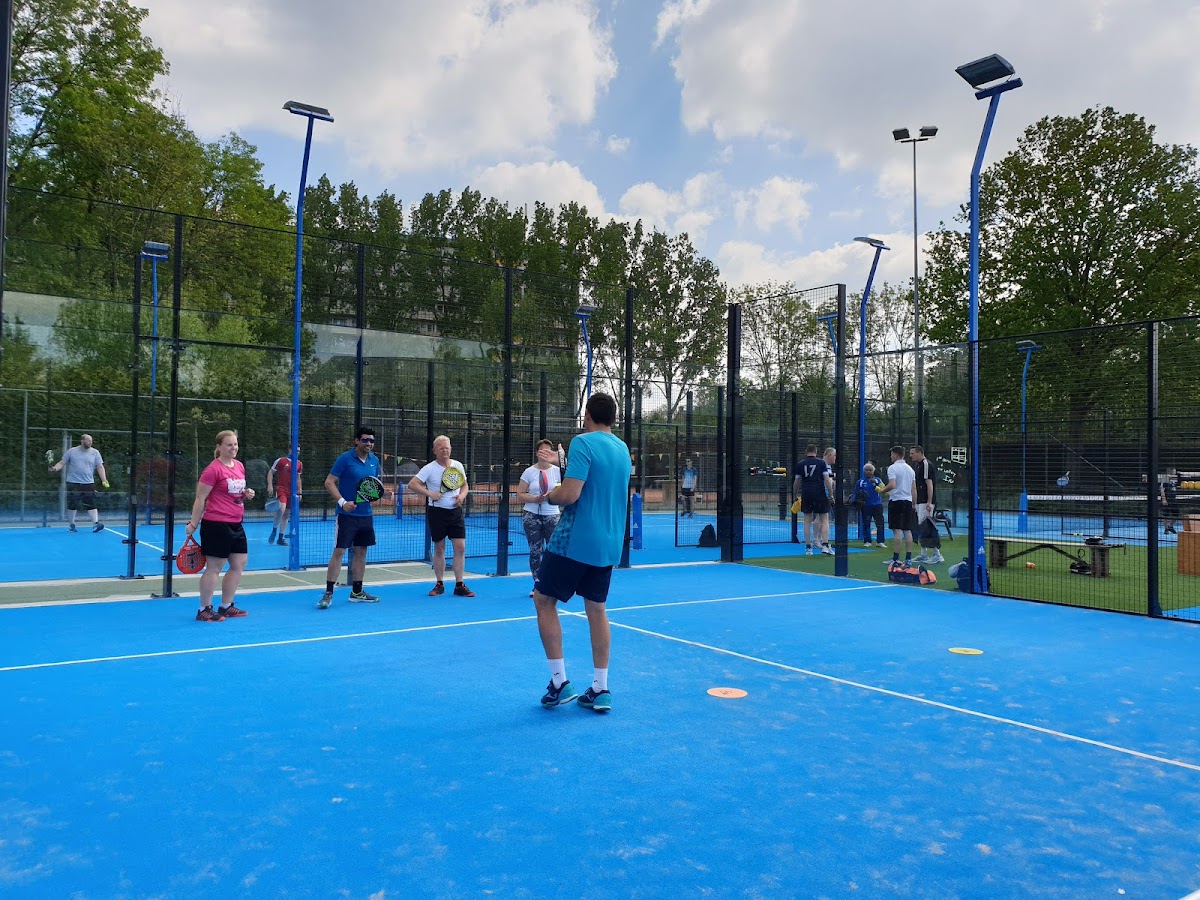 Buitenbanen padel club met blauwe hardcourts, spelers in actie en LED verlichting