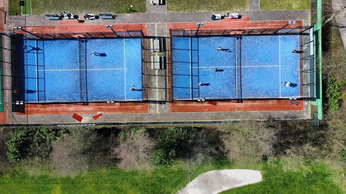 Luchtfoto van twee outdoor padelbaanën met blauwe hardcourt en glazen wanden