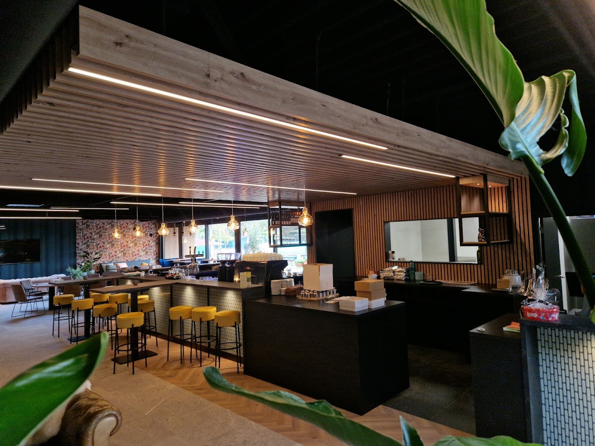 Modern padel club interieur met bar, gele barkrukken en LED-verlichting 's nachts