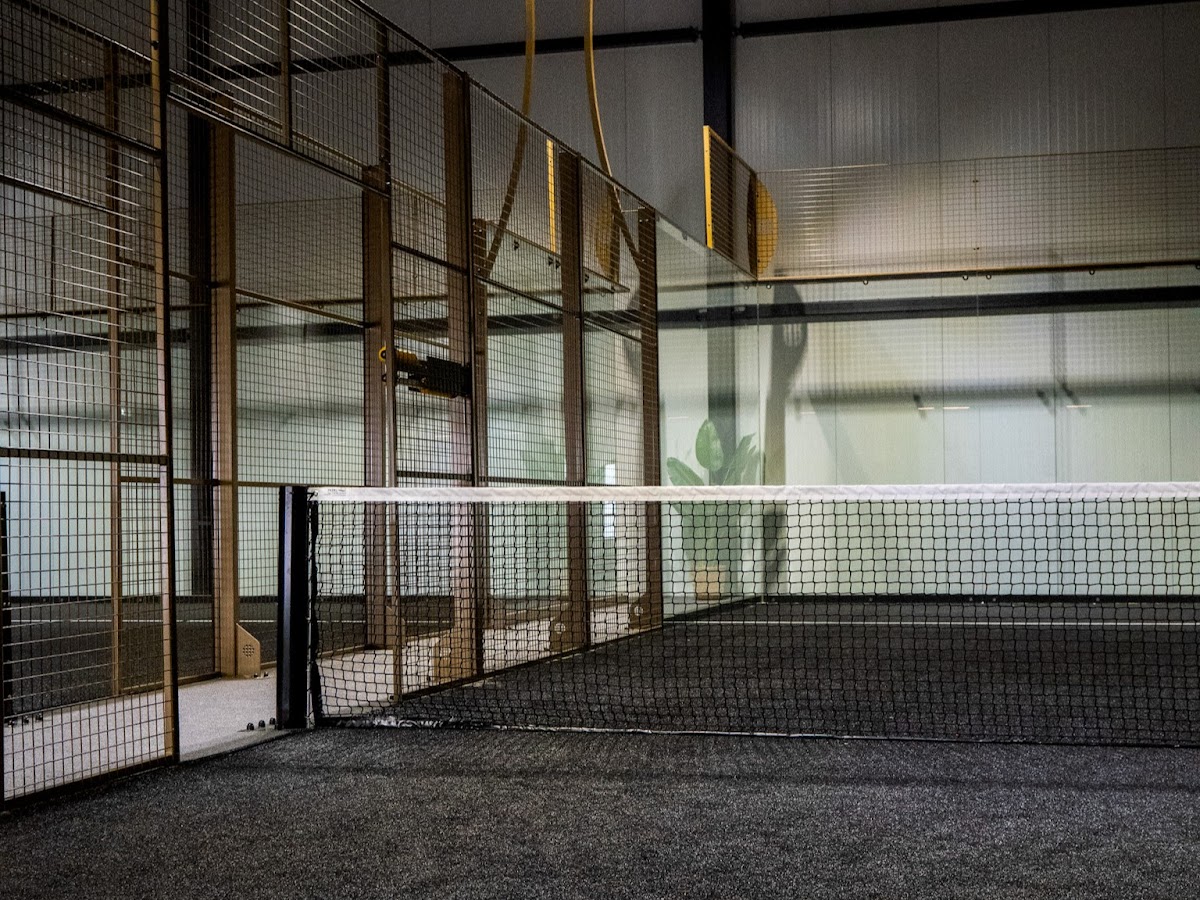 Binnenpadelbaanclub met netjes, houten wanden en kunstverlichting
