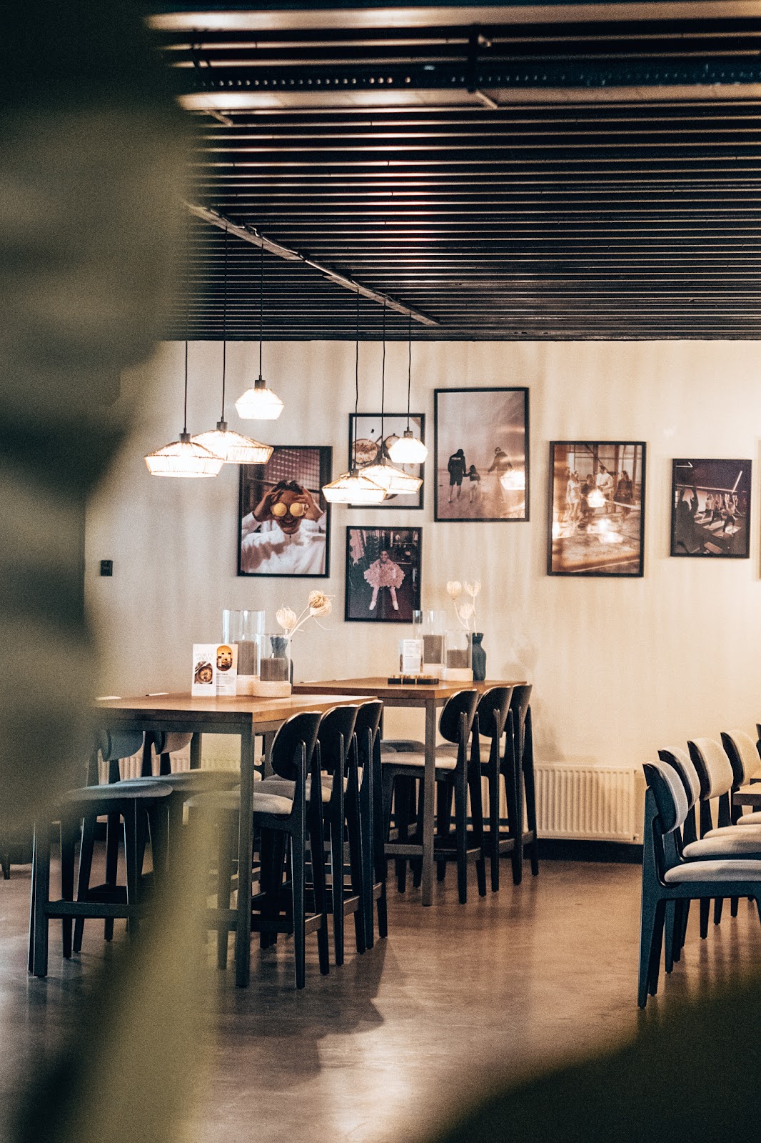 Moderne padel clubruimte met bar, hangende verlichting en wandfoto's