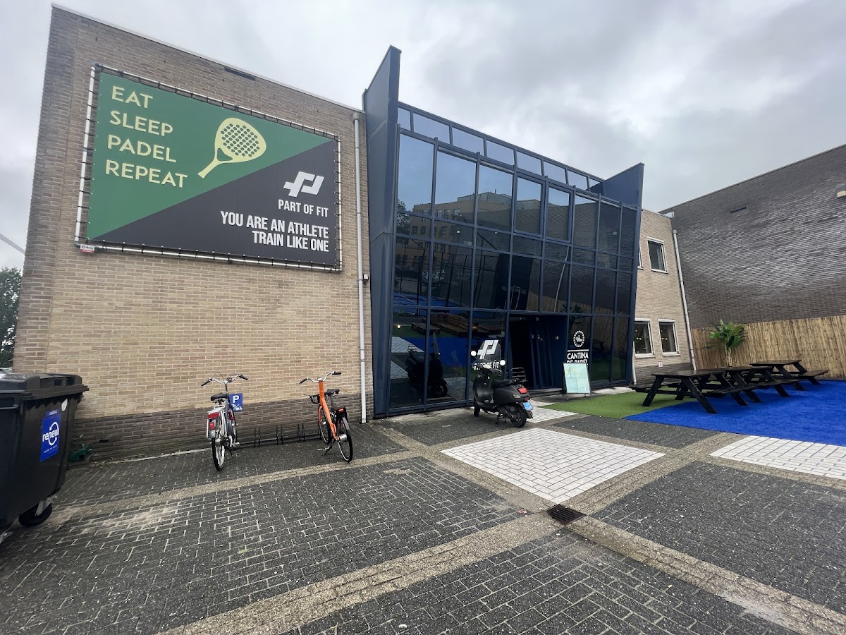 Padel club voorkant met groen kunstgras court, glazen ingang en promobord